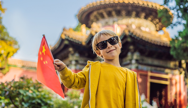 Young blond boy holding Chinese flag